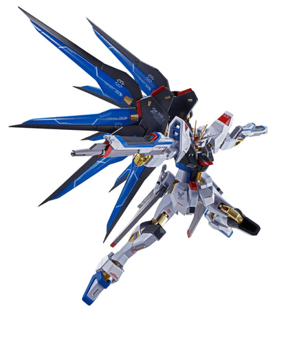 White, blue, and gold Freedom Gundam model in a dynamic flight pose, wings spread, arms extended, against white