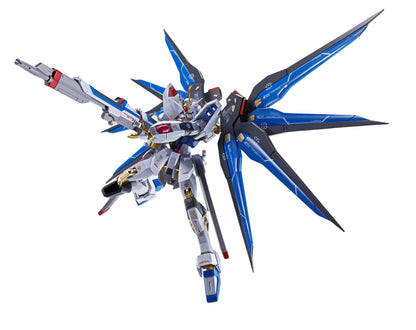 White, blue, and gold Gundam model with large deployed blue wings, dynamically holding a rifle