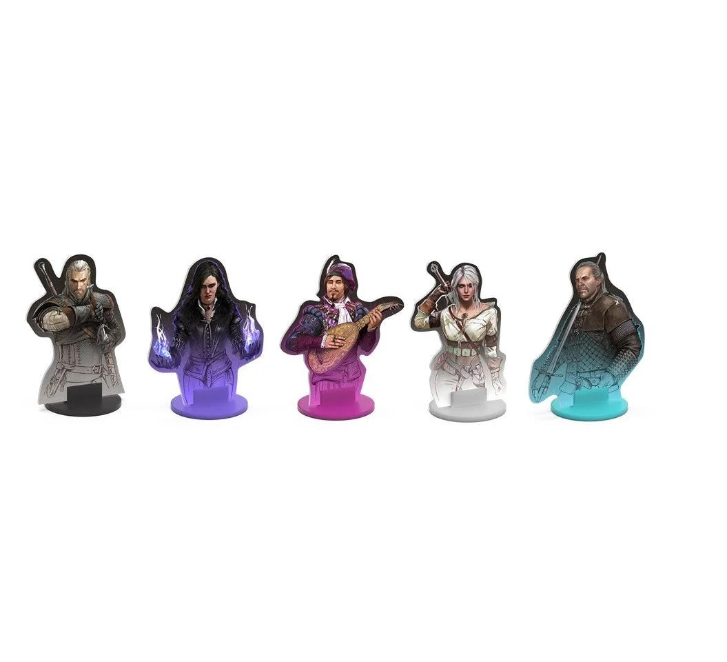 Five Witcher character standees: Geralt, magic-wielding Yennefer, lute-playing Dandelion, sword-wielding Ciri, and Vesemir. Some glow