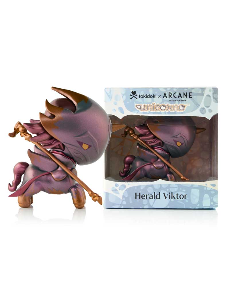 Tokidoki x Arcane Unicorno 'Herald Viktor' figurine, purple and bronze, holding a staff, displayed next to its product box
