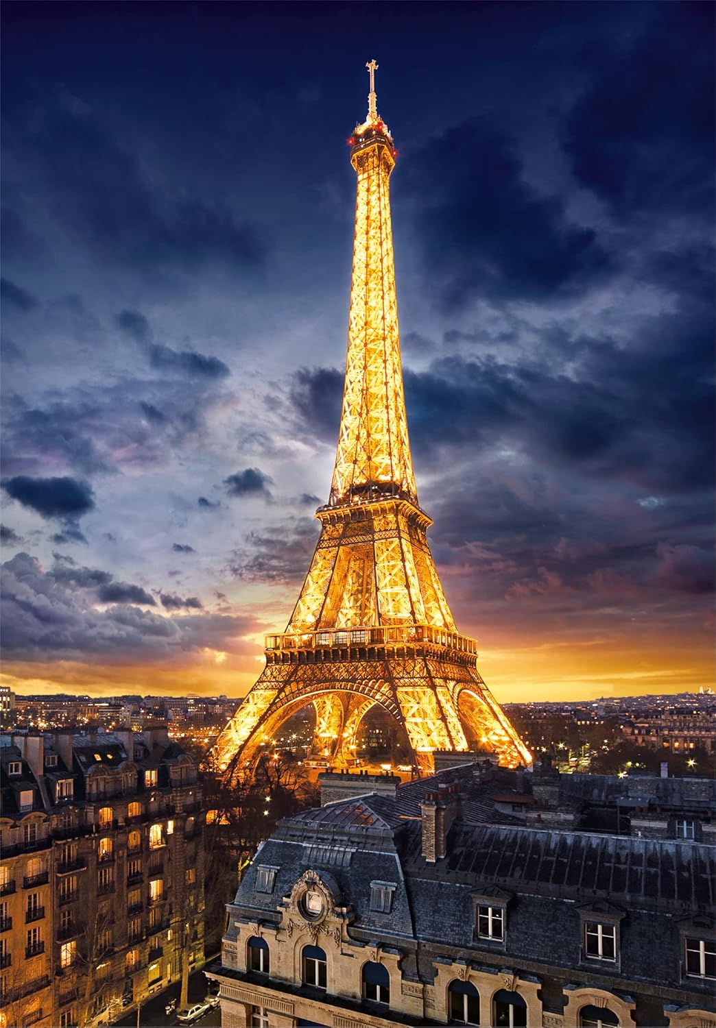 The Eiffel Tower glows golden against a dramatic twilight sky and Paris cityscape