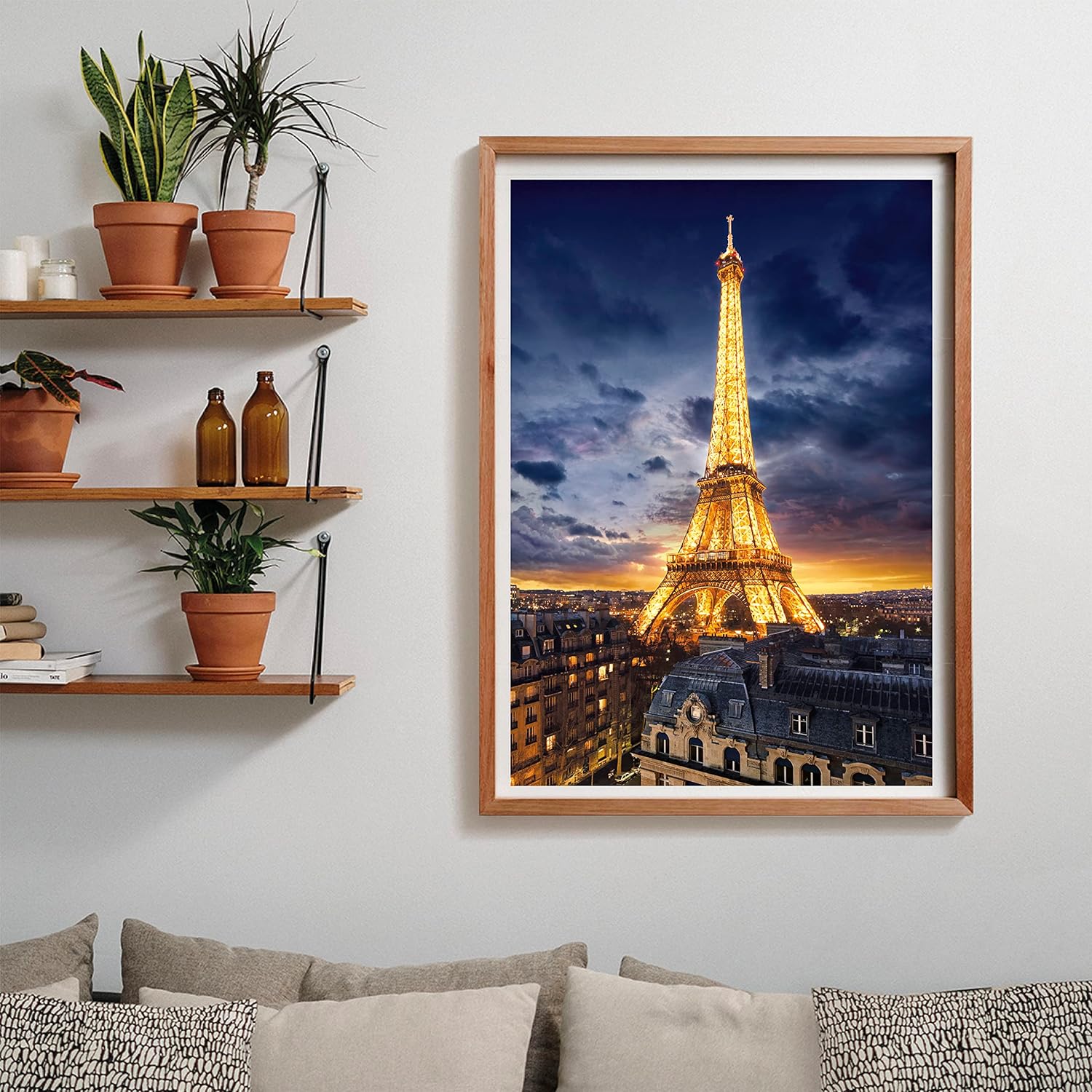Framed art shows the illuminated Eiffel Tower at dusk over Parisian buildings