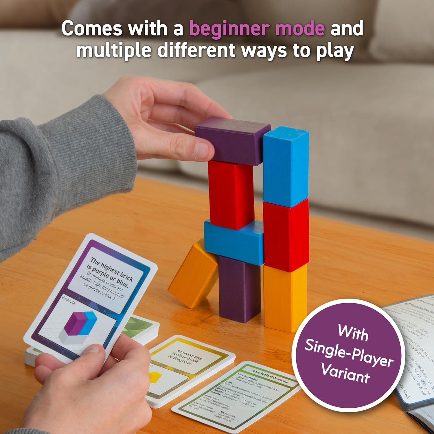 A hand stacks colorful wooden blocks into a tower, holding a game card with building instructions