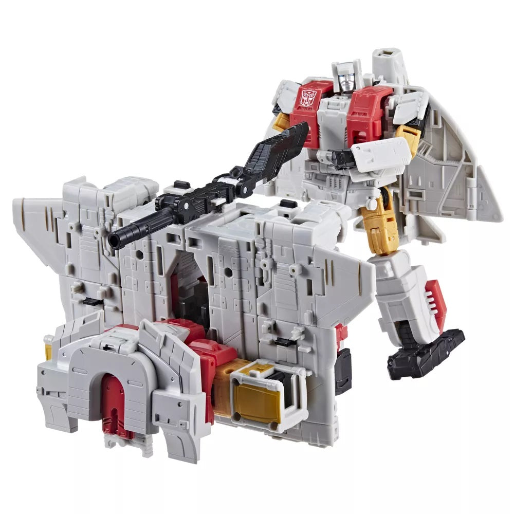 White, red, gold Autobot robot with jet wings, holding a blaster, stands by a gray weapon platform