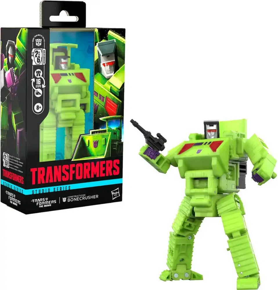 Neon green Transformers Bonecrusher robot action figure, holding a black gun, beside its packaging