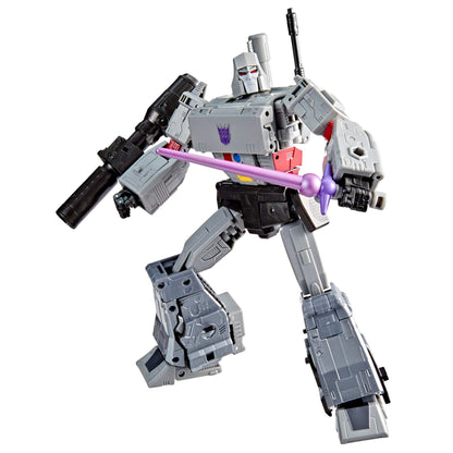 Gray Megatron Transformer action figure, Decepticon symbol on chest, holding a black cannon and purple sword