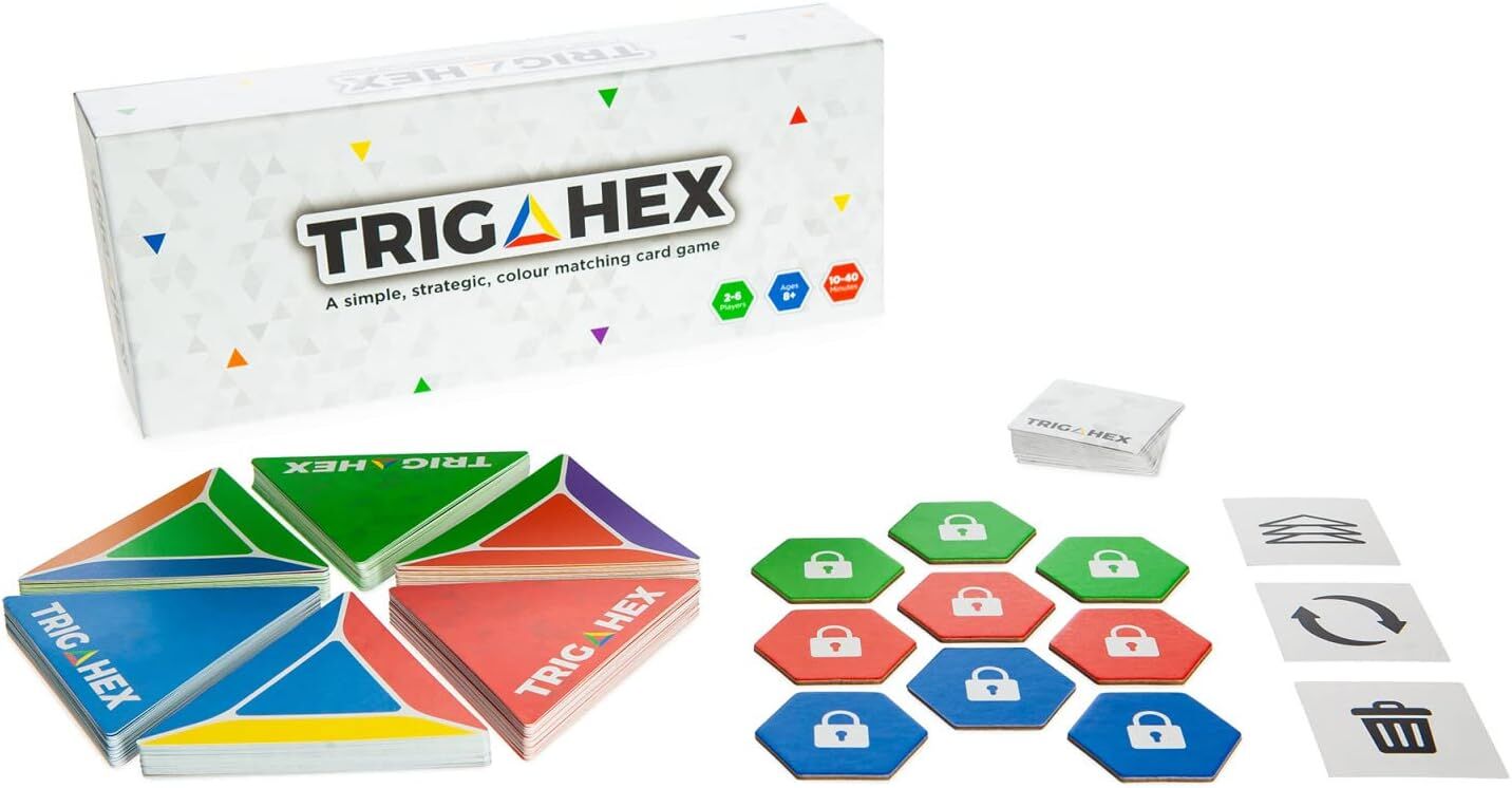 TRIGAHEX card game components spread out: white box, stacks of hexagonal cards with colorful triangles, and colored padlock tokens