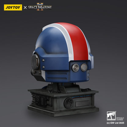 A Warhammer 40,000 Space Marine helmet bust, blue with a red and white stripe, on a mechanical stand