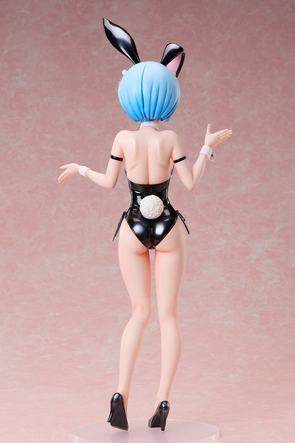 Back view of a blue-haired anime figure wearing a shiny black bunny suit with ears and a white tail, posing with arms out