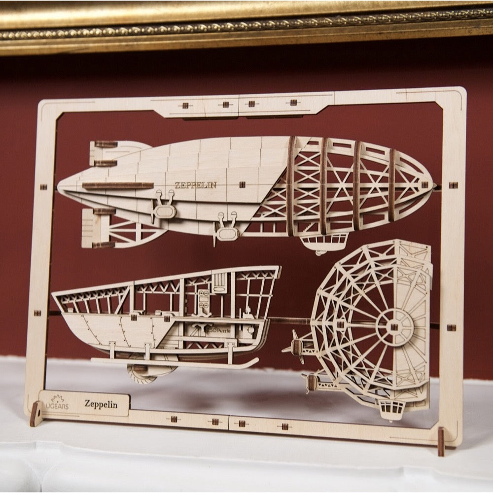 Wooden 3D puzzle of a Zeppelin, labeled 'ZEPPELIN', with intricate pieces still in its laser-cut frame