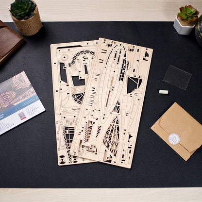 Two laser-cut wooden sheets for a Zeppelin model, with instructions, on a dark desk