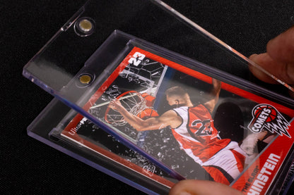 Hands inserting a basketball trading card with a dunking player into a clear magnetic case