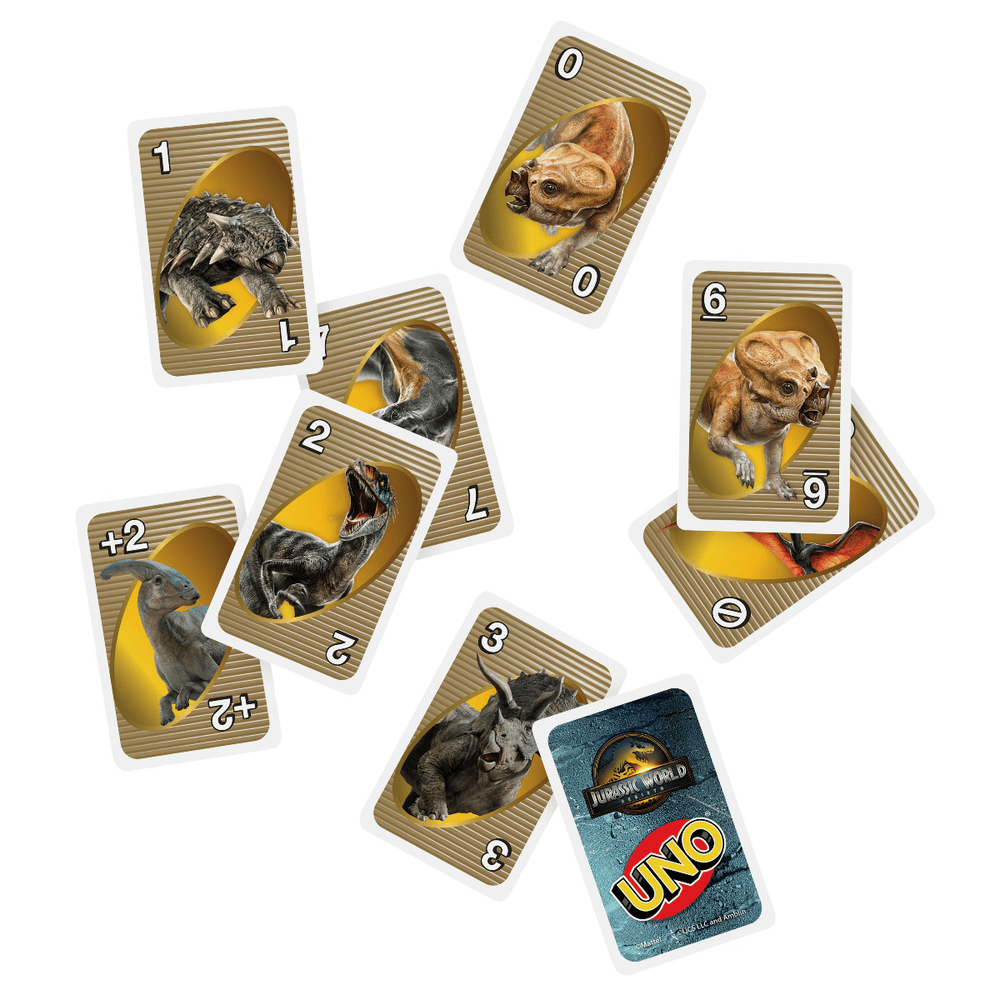 Scattered Jurassic World Uno cards with various dinosaur illustrations on a white background