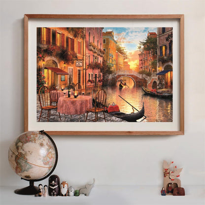 Framed painting of a vibrant Venetian canal at sunset, with gondolas, a bridge, and a quaint outdoor cafe