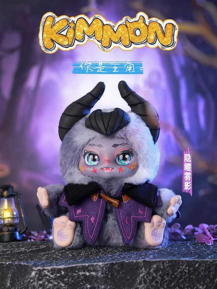 Plush Kimmon monster doll with horns, purple vest, and large eyes, sitting in a mystical purple forest setting