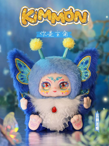 Fluffy blue KIMMON character doll with large iridescent eyes, pom-pom antennae, and butterfly wings