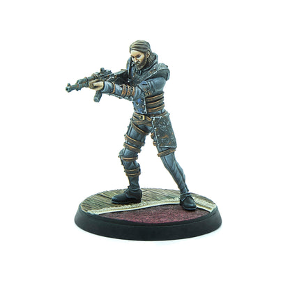 Painted miniature of a bearded man in dark, tactical clothing, aiming a rifle forward