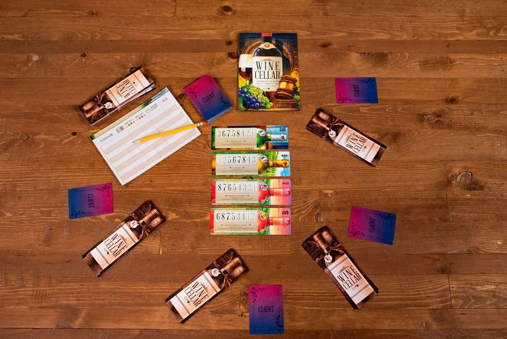 Wine Cellar board game pieces including rulebook, score sheet, pencil, and various cards are arranged on a wooden table