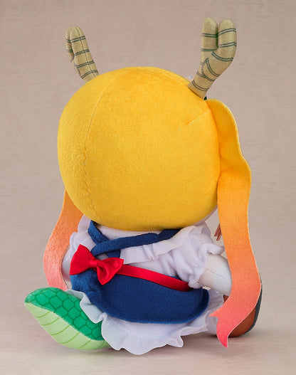 A sitting Tohru plush from behind. Features yellow head, striped horns, orange gradient pigtails, blue maid dress, & green dragon tail