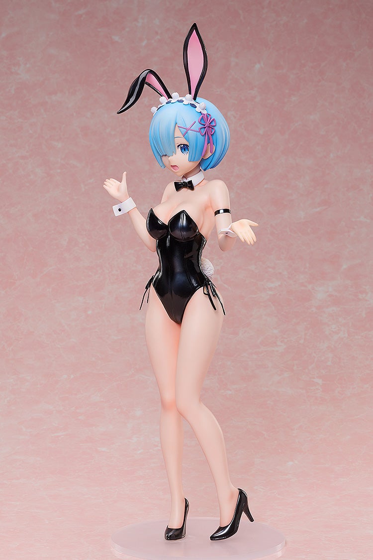 Anime figure of Rem in a black bunny suit with bunny ears and blue hair, standing against a pink background