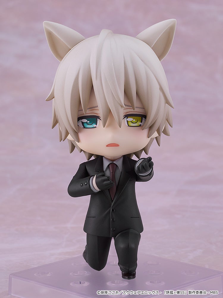 White-haired anime figure with fox ears and heterochromatic eyes, in a black suit, kneeling and reaching out.