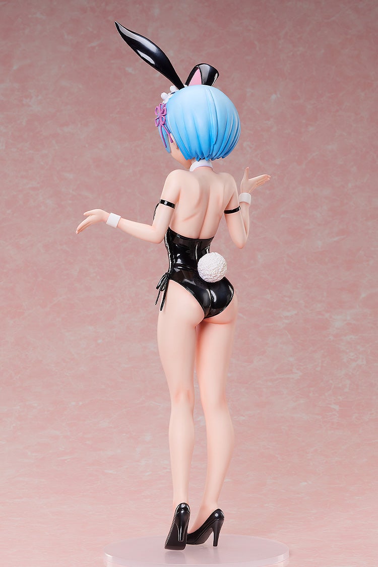 Figure of Rem with blue hair, in a black shiny bunny suit with ears and a white tail, posing from behind