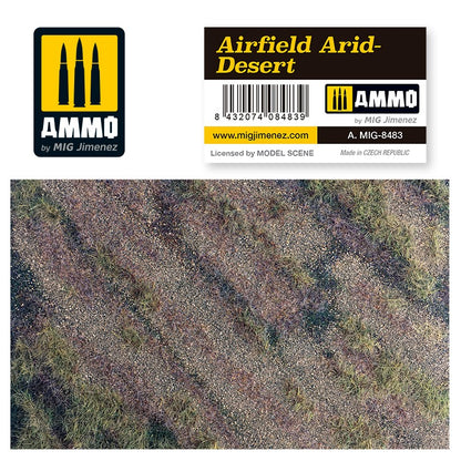 AMMO by MIG Jimenez 'Airfield Arid-Desert' terrain with label. Top-down view of dry, gravelly ground and sparse grass.