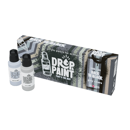 A Scale 75 Drop and Paint Back To Black Paint Set with two light grey paint bottles, Arctic Grey and UFO Grey, next to its box of acrylic airbrush paints