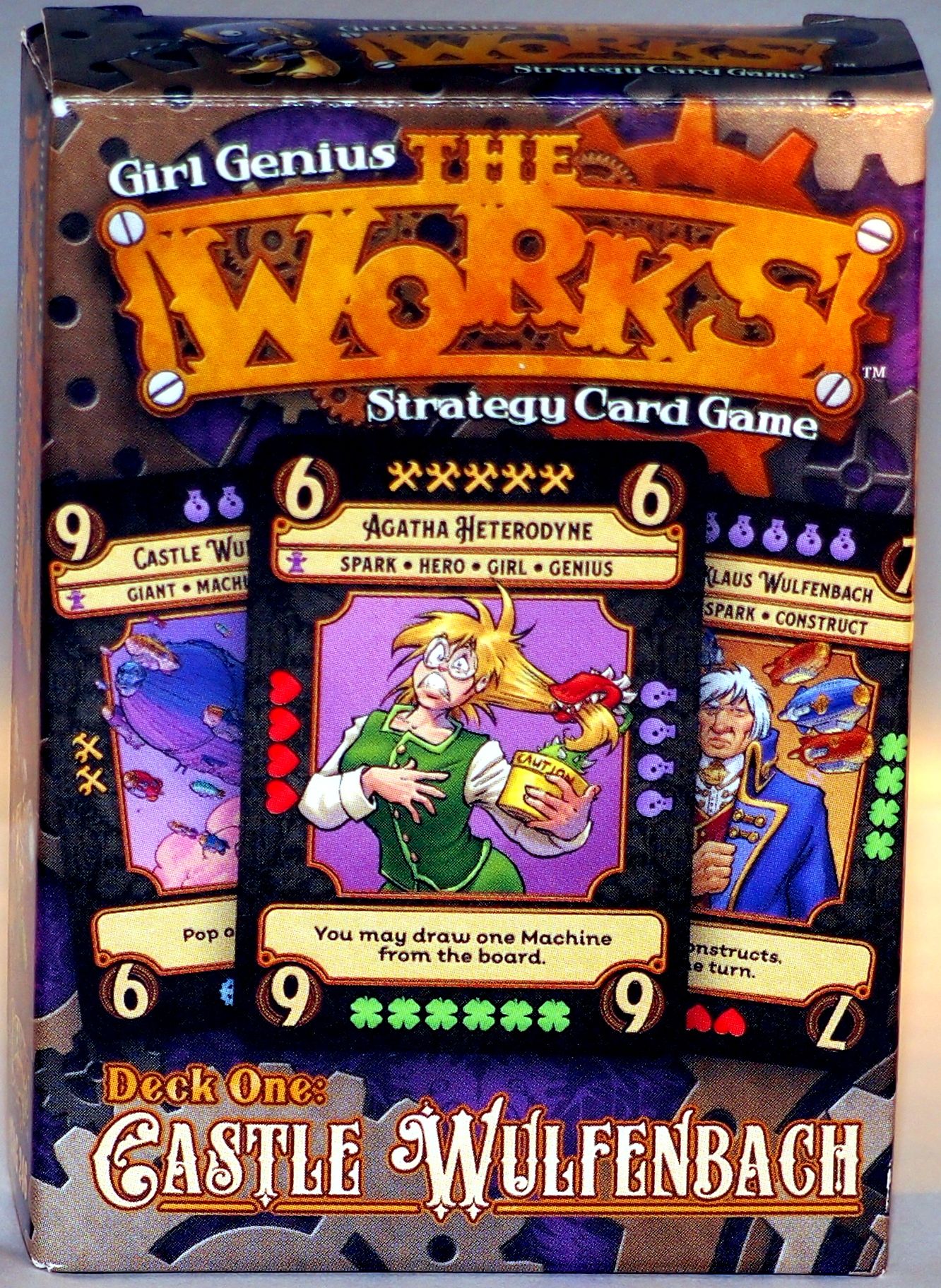 Box for "Girl Genius: The Works" strategy card game. A central character card shows a startled blonde woman, Agatha Heterodyne