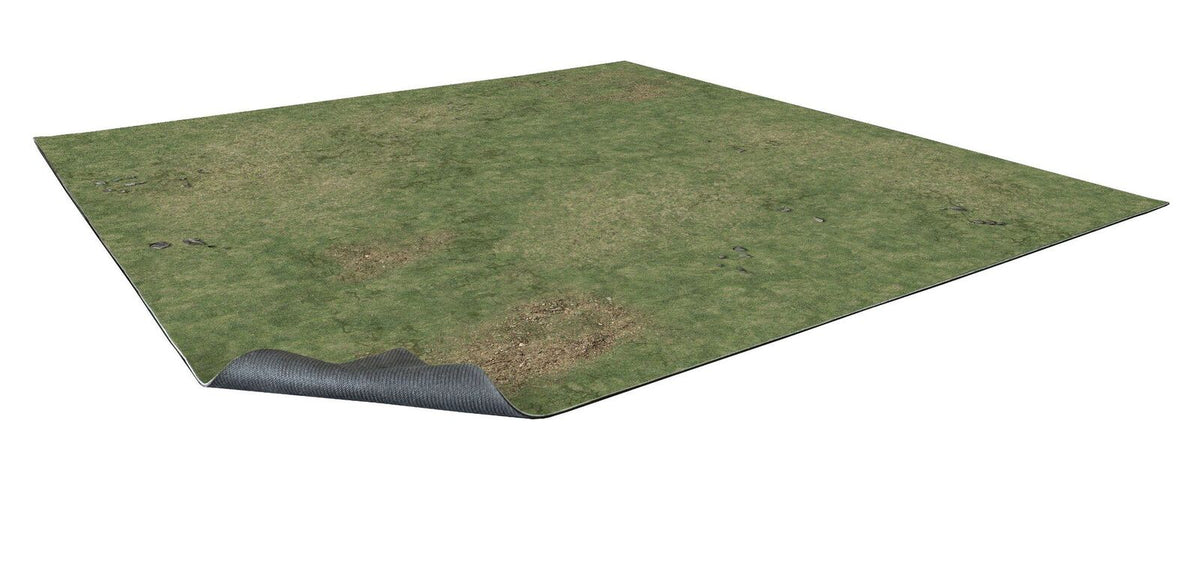 Rectangular game mat with green grass and dirt patches, one corner lifted to show its dark, textured underside.