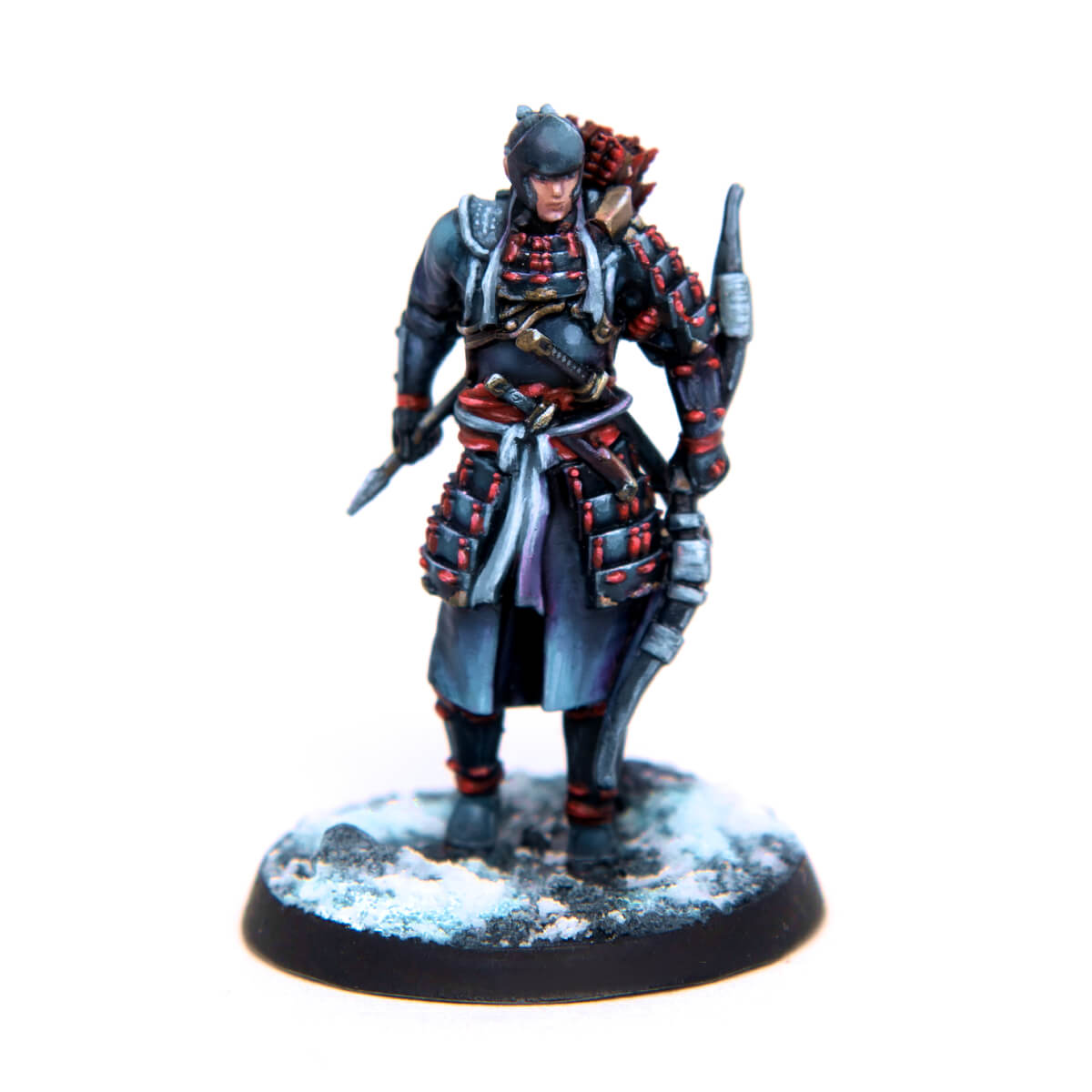 Painted miniature of a samurai archer in dark, red-laced armor, holding a spear and bow, standing on a snowy base