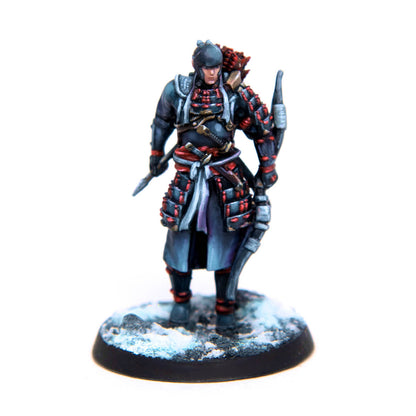 Painted miniature of a samurai archer in dark, red-laced armor, holding a spear and bow, standing on a snowy base