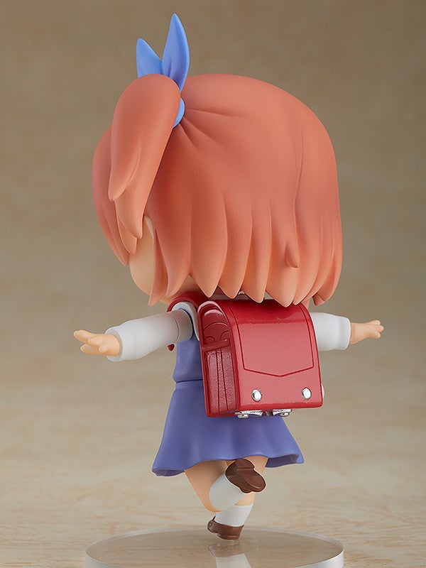 Figure of a young girl with orange hair in pigtails wearing a red backpack and blue skirt reaching out