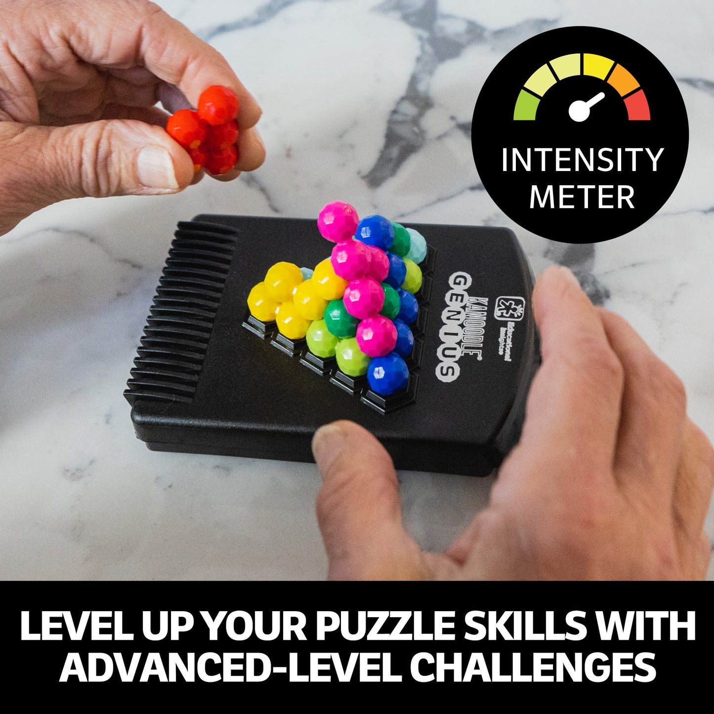 Hand placing a red piece onto the Kanoodle Genius puzzle board, filled with stacked colourful balls