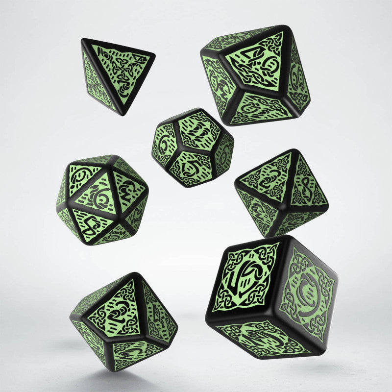 Seven black polyhedral dice with glowing green Celtic knot designs and numbers float against a white background