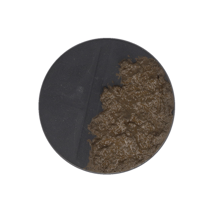 A dark gray circular base half-covered in thick, lumpy brown mud.