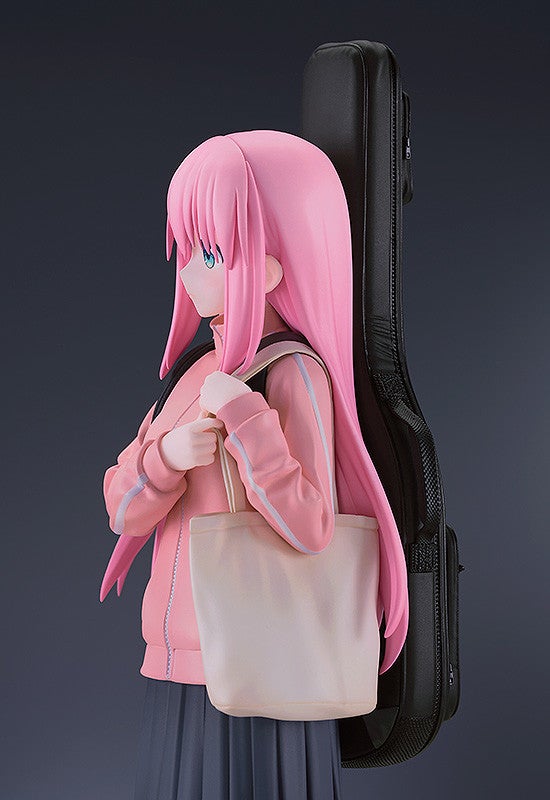 Pink-haired anime girl figure with blue eyes wearing a pink tracksuit and gray skirt