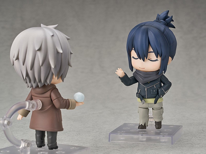 Two small stylized figures face each other one in a brown coat holds a small orb the other in a dark jacket waves