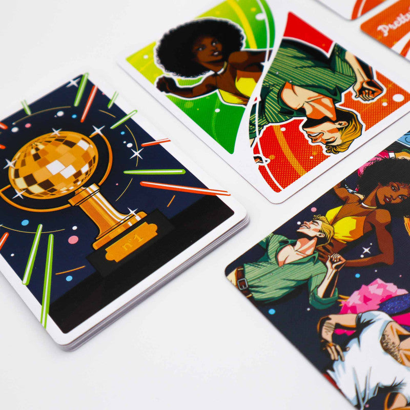 Colorful game cards: a disco ball trophy card on top of a stack, with other cards showing dancing figures