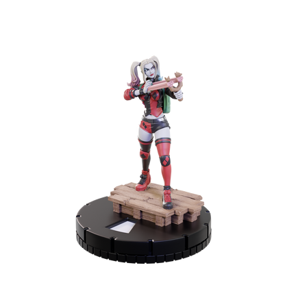 A DC HeroClix Starter Set 2024 figure of Harley Quinn in red and black, holding a crossbow, on a wooden pallet and black game base