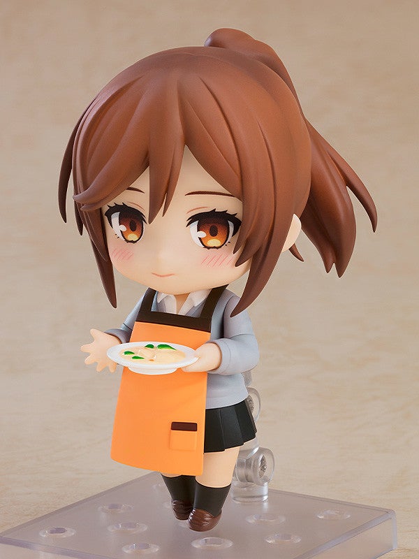 Nendoroid figure of a girl in an orange apron holding a plate of food