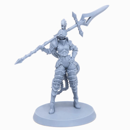 Unpainted grey miniature of an armored female warrior holding a polearm across her shoulders