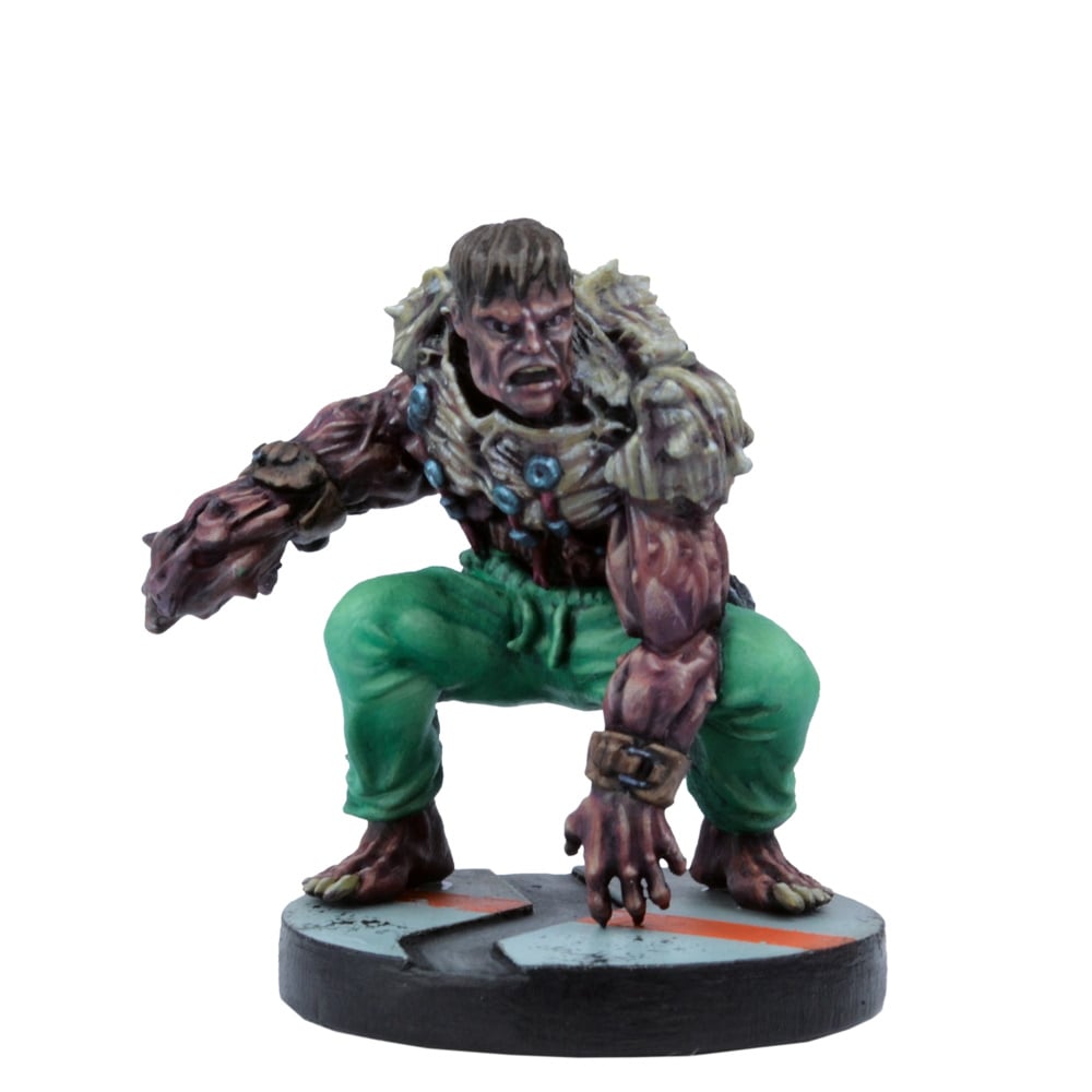A muscular, mutated humanoid game miniature in green pants and bone armor, crouching low with an angry expression