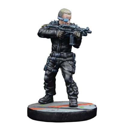 Sci-fi soldier miniature in dark tactical gear with a blue visor, aiming a rifle on a marked base