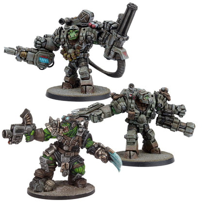 Three green-skinned Ork miniatures: two in bulky grey power armor with heavy weapons, one smaller Ork with a gun and blade