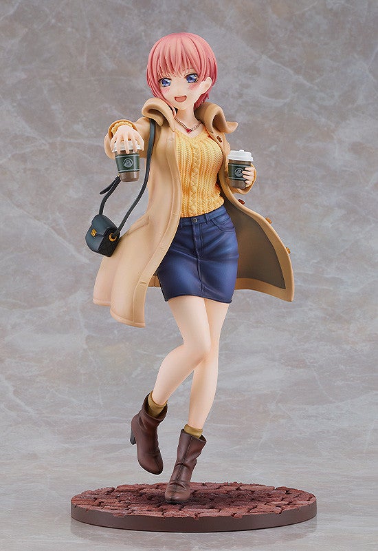 Anime figure of a woman with pink hair in a beige coat yellow sweater and denim skirt holding two coffee cups