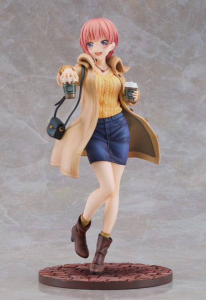 Anime figure of a woman with pink hair in a beige coat yellow sweater and denim skirt holding two coffee cups