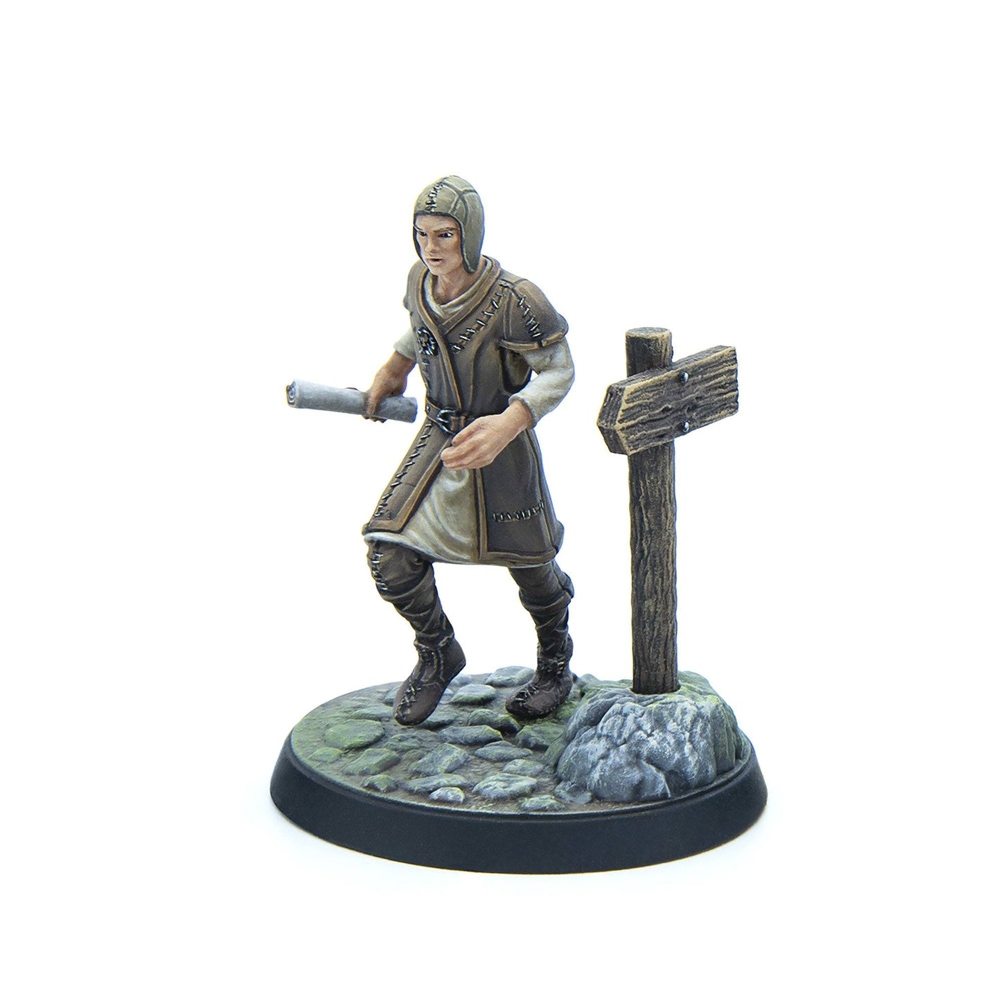 A painted miniature figure of a medieval-style person in a hooded cap and tunic, striding with a scroll past a wooden signpost