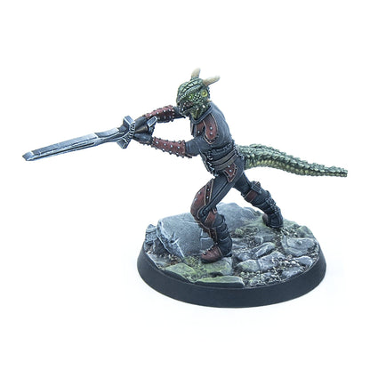 A detailed miniature of a green, horned reptilian warrior in dark armor, gripping a sword and poised on a rocky base