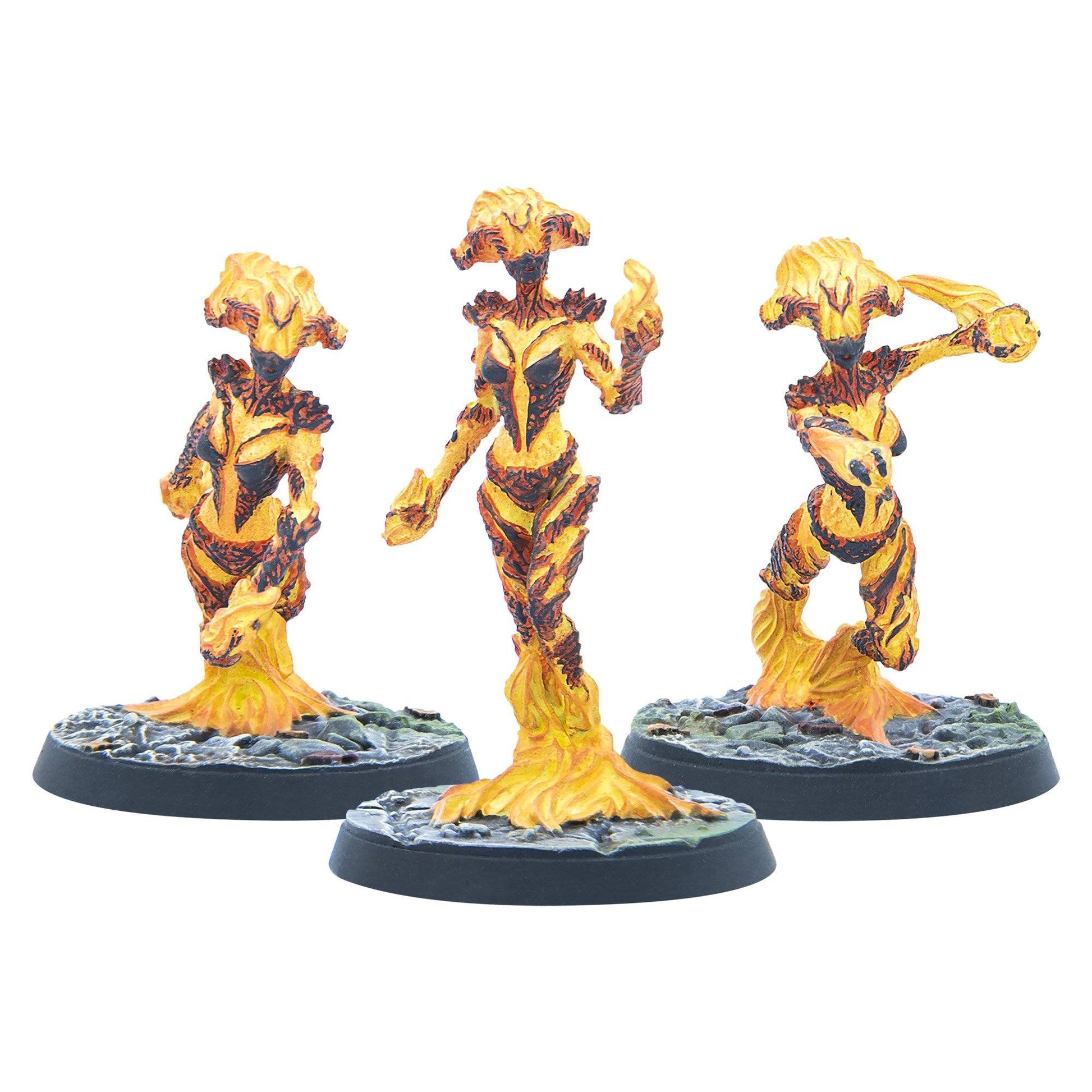 Three yellow, orange, and black molten humanoid miniatures in dynamic poses on round bases